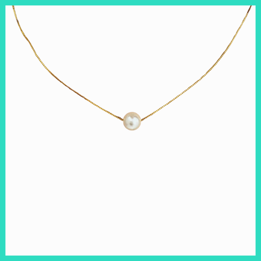 Gold necklace with a single pearl pendant on a white background