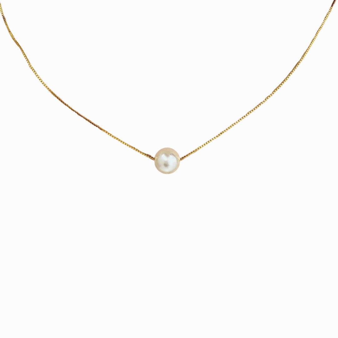 Gold necklace with a single pearl pendant on a white background