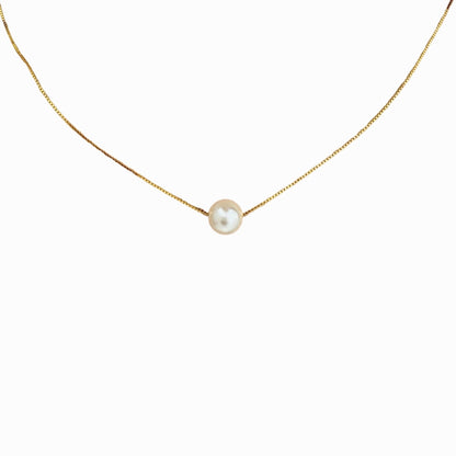 Gold necklace with a single pearl pendant on a white background