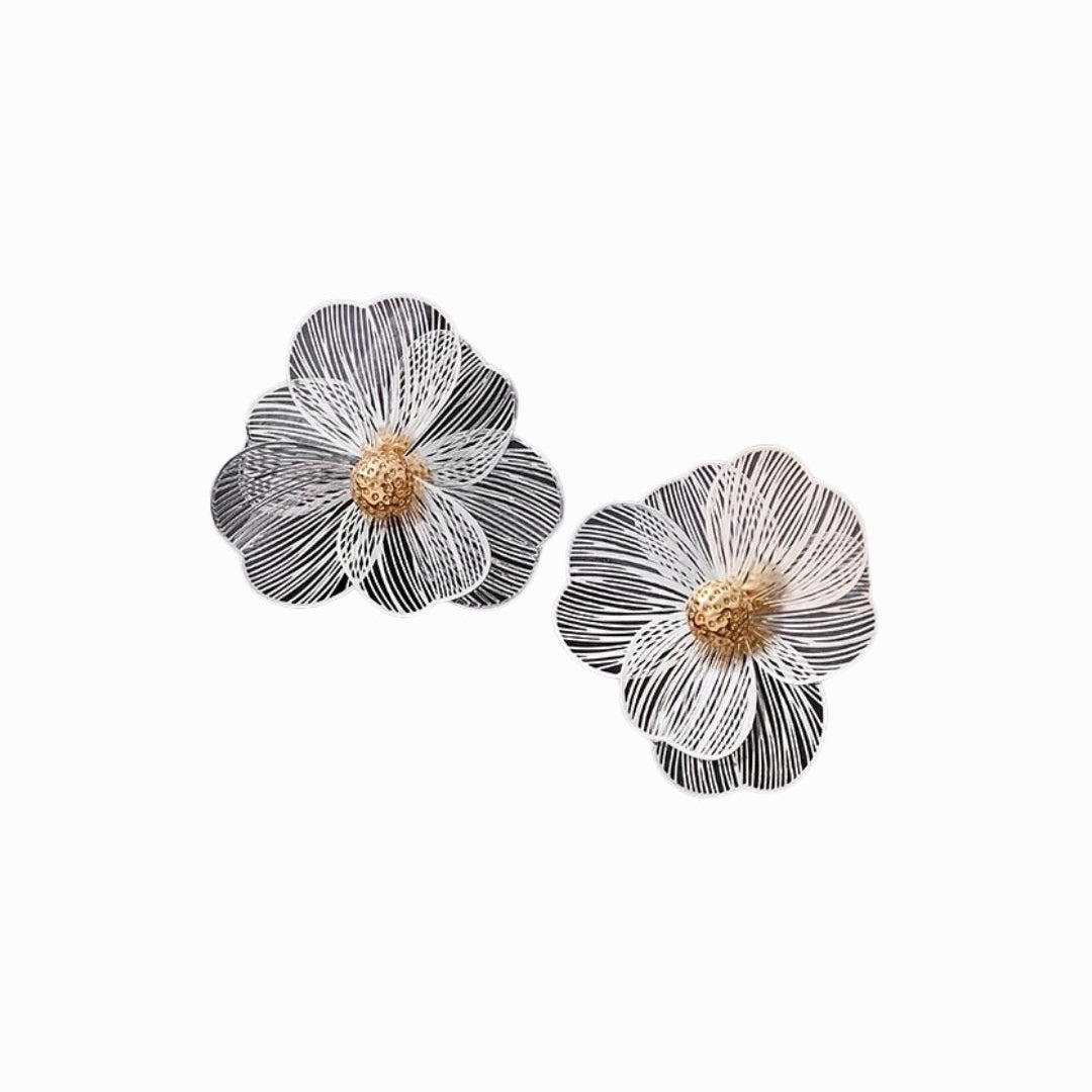 Pair of silver floral earrings on a white background