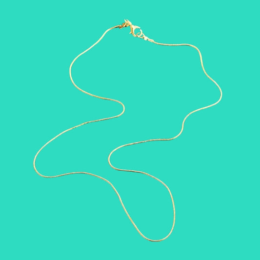 Gold necklace on a turquoise background