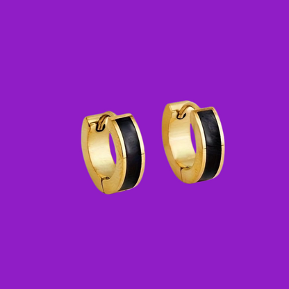 Gold hoop earrings with black centers on a purple background