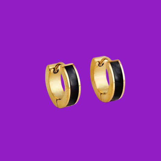 Gold hoop earrings with black centers on a purple background