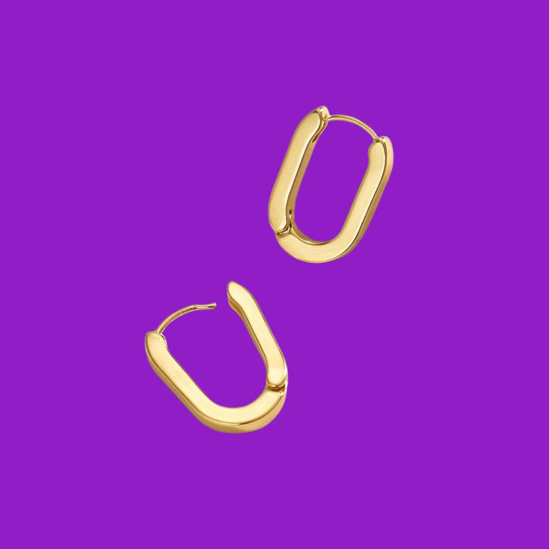 Gold hoop earrings on a purple background