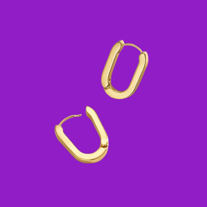 Gold hoop earrings on a purple background