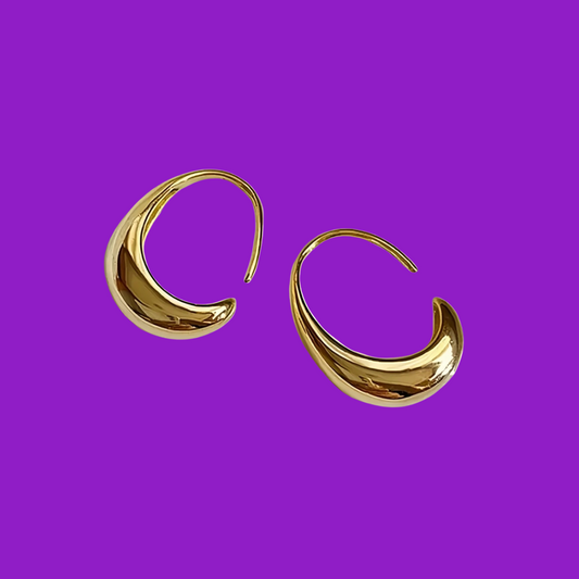 Gold hoop earrings on a purple background
