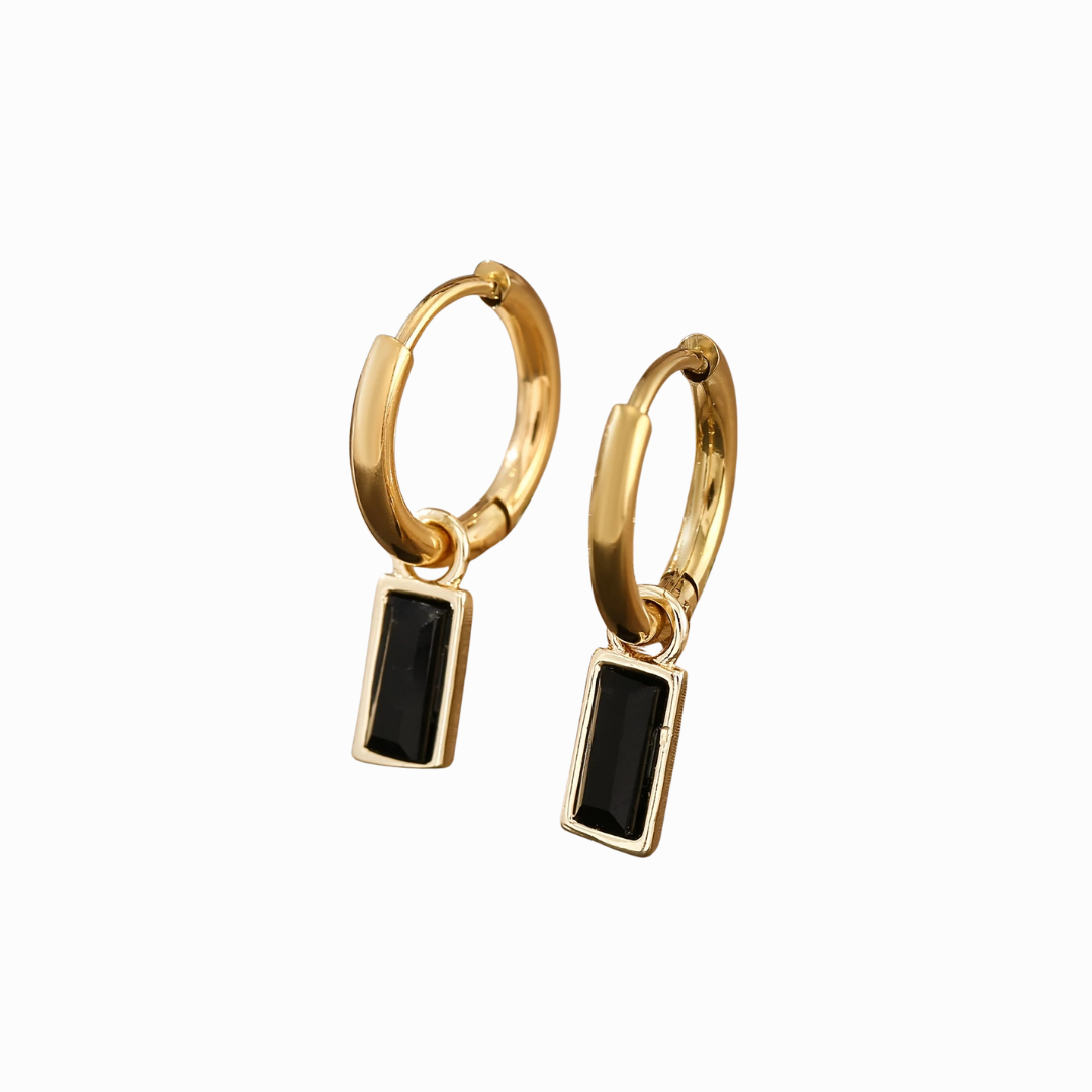 Gold hoop earrings with black rectangular stones on a white background