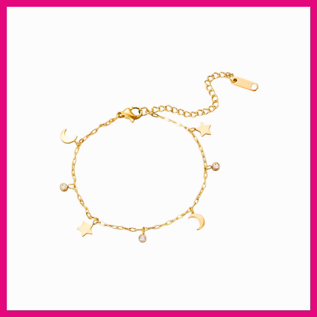 Gold bracelet with star and moon charms on a white background