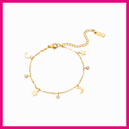 Gold bracelet with star and moon charms on a white background