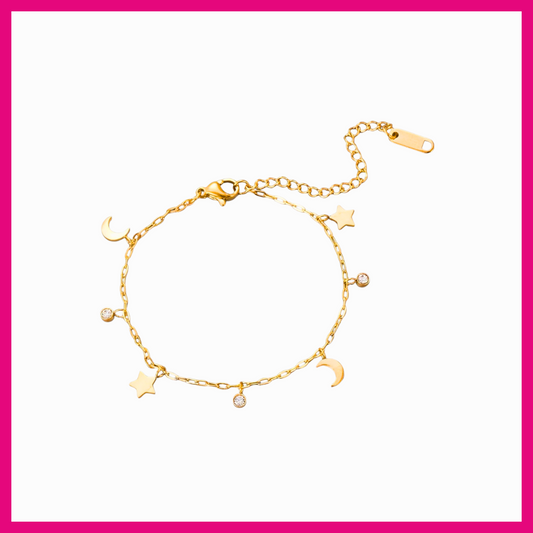 Gold bracelet with star and moon charms on a white background