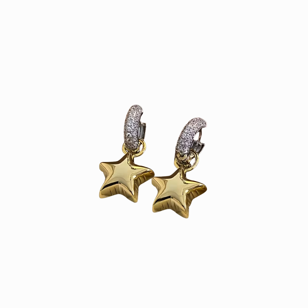 Gold star-shaped earrings with diamond accents on a white background