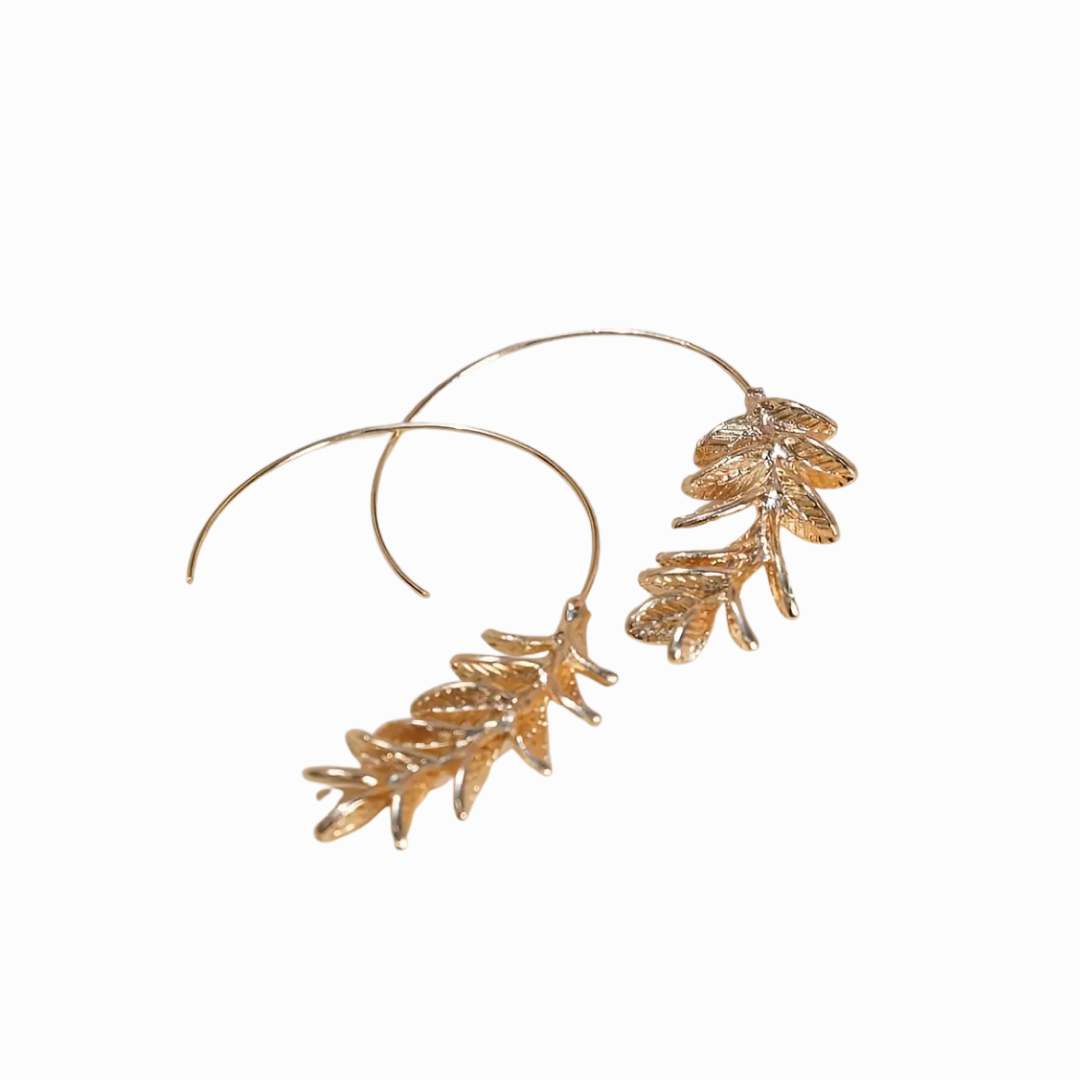 Gold leaf hoop earrings on a white background