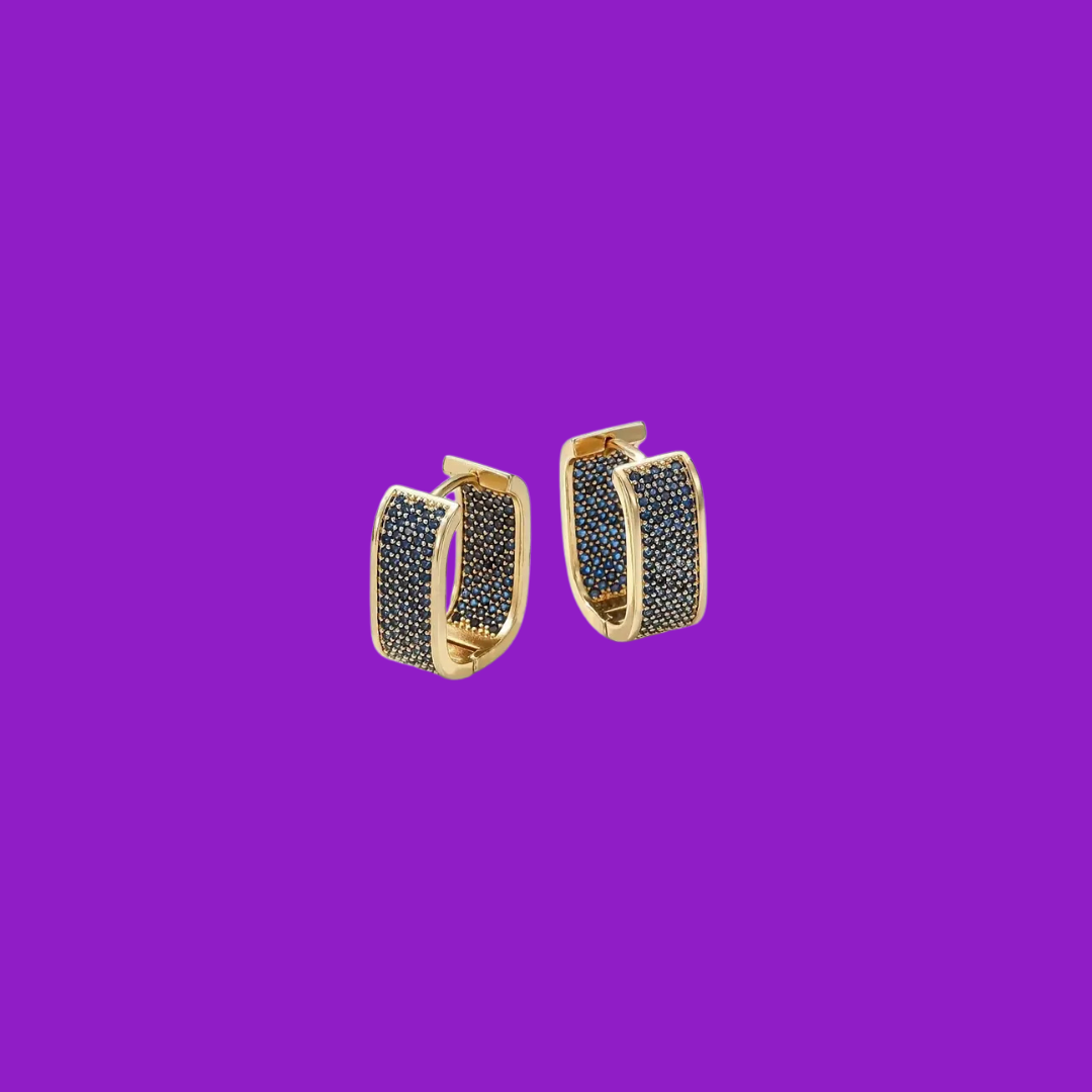 Gold hoop earrings with black stones on a purple background