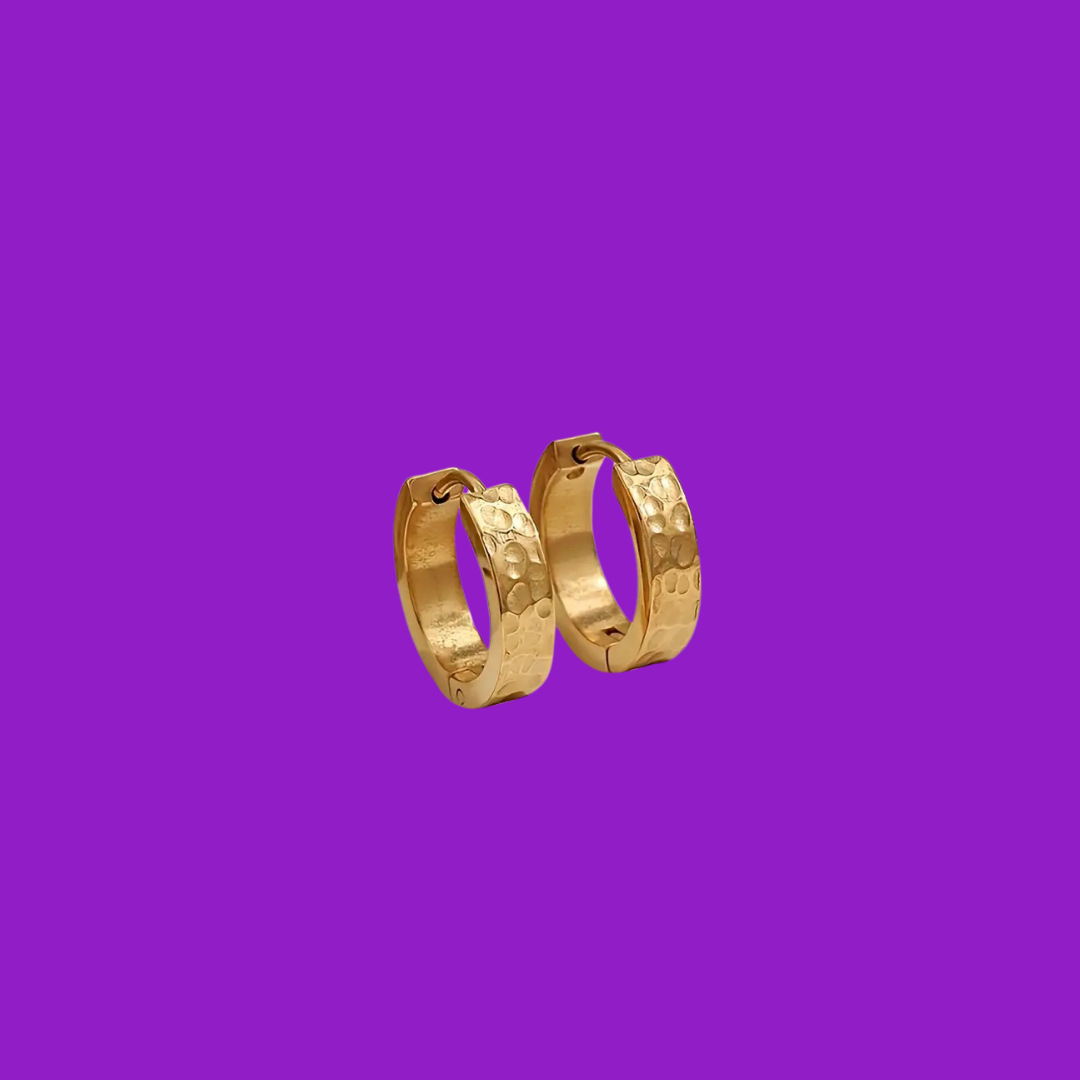 Gold hoop earrings on a purple background