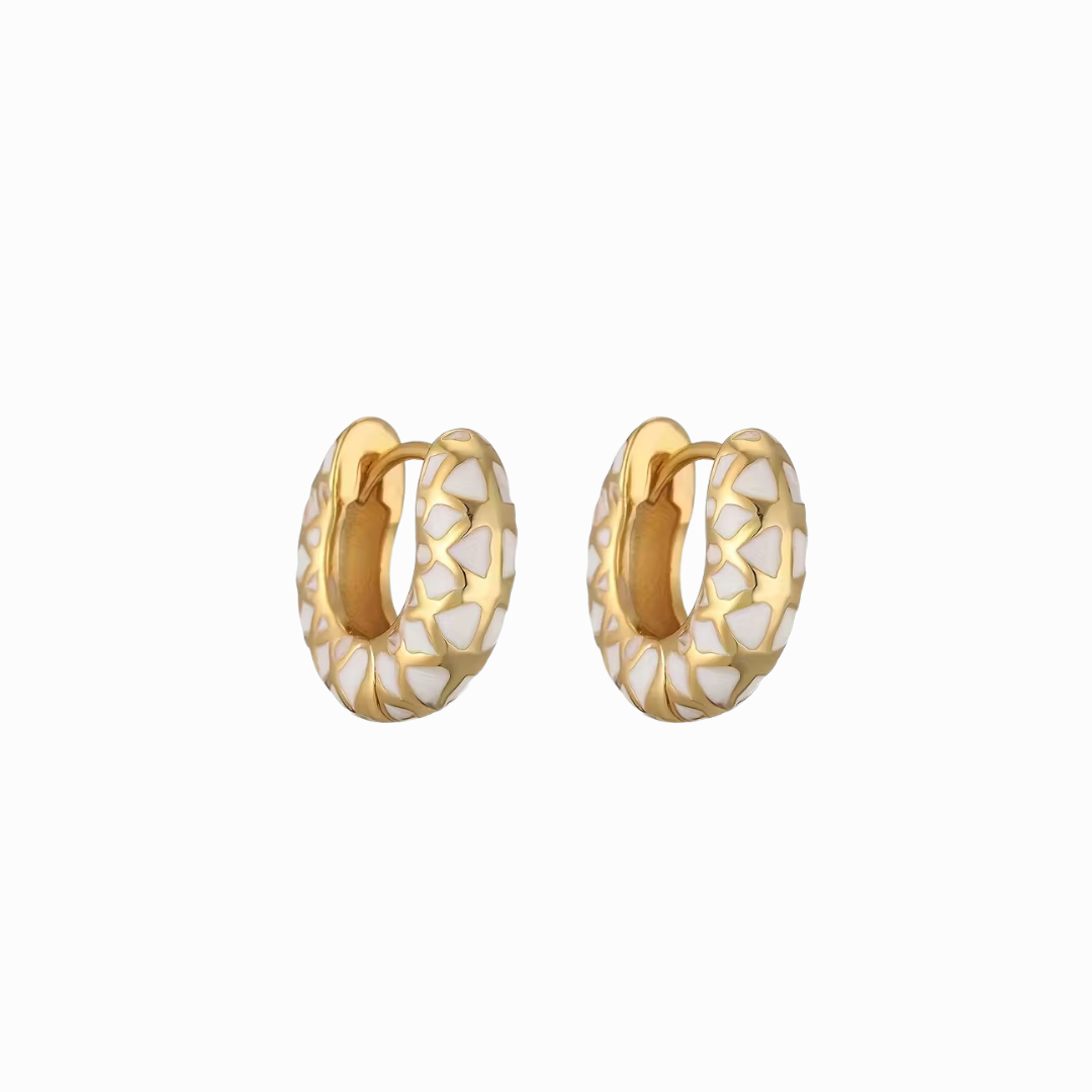 Gold hoop earrings with white marbled pattern on a white background