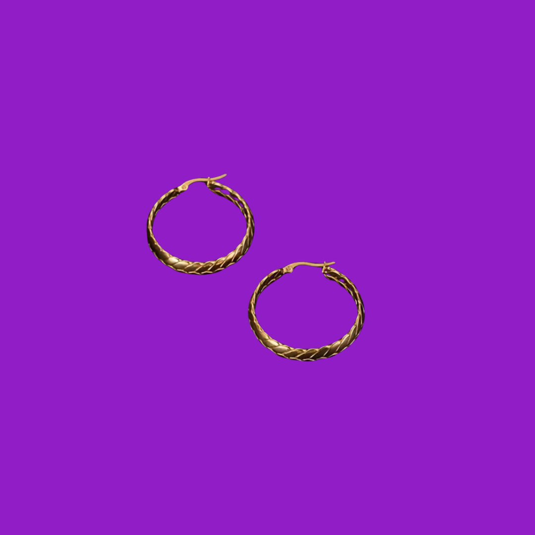 Gold hoop earrings on a purple background