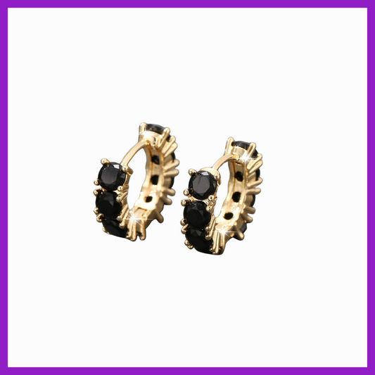 Gold hoop earrings with black gemstones on a white background