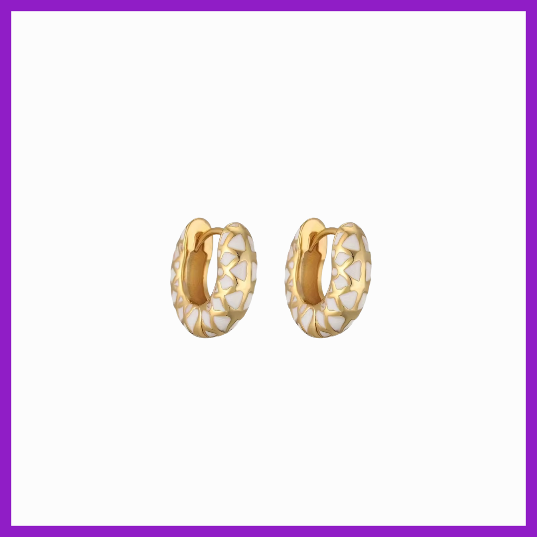 Gold hoop earrings with white pattern on a white background