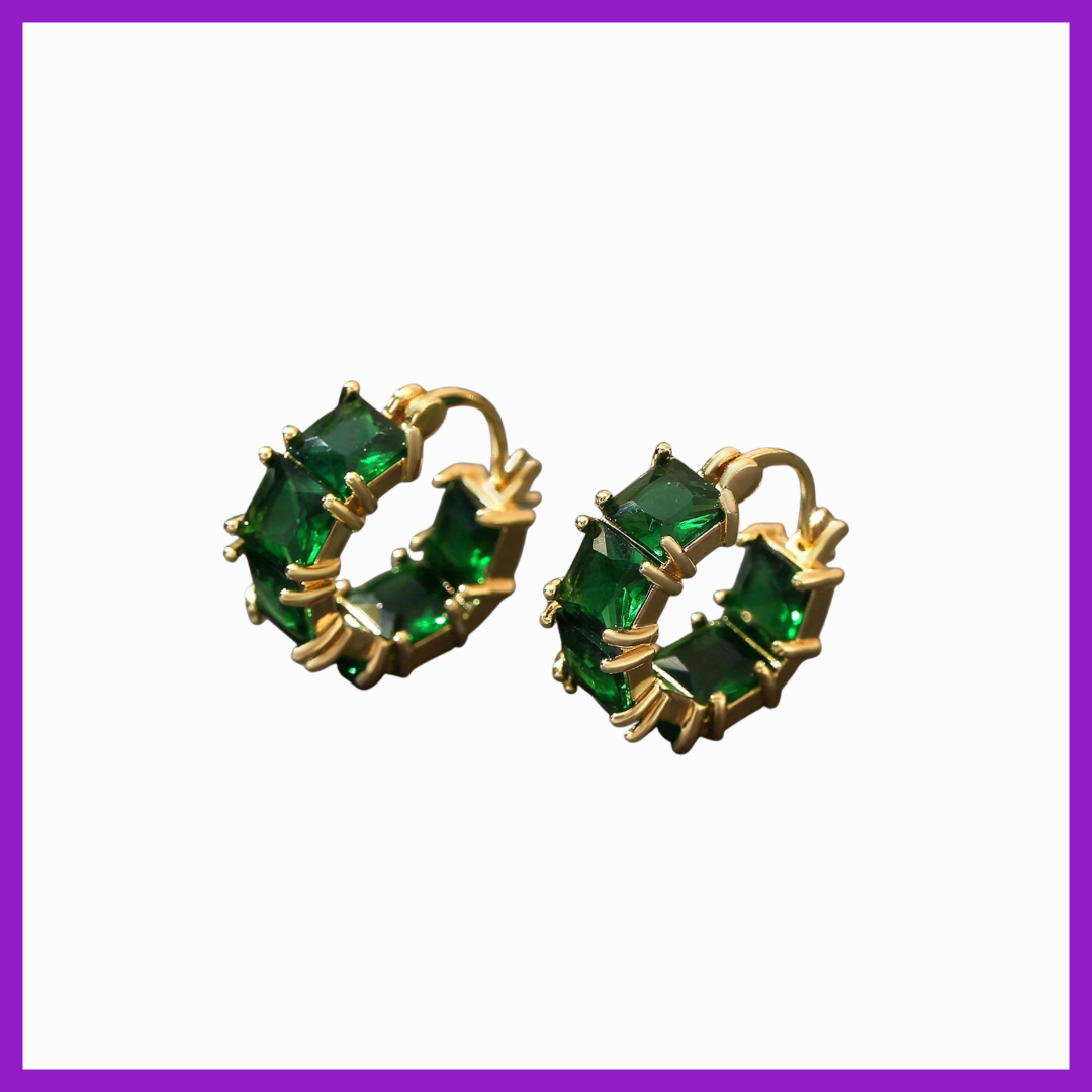 Gold hoop earrings with green gemstones on a white background