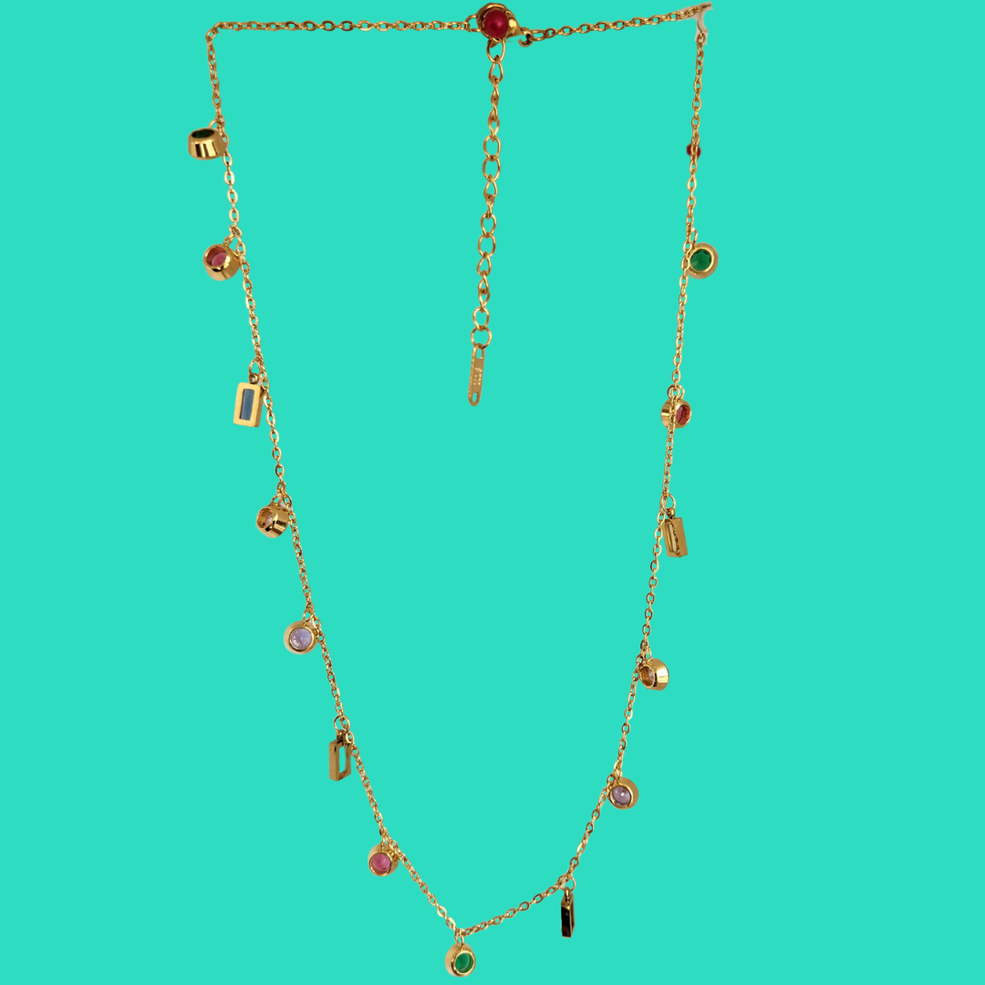 Gold necklace with small pendants on a teal background