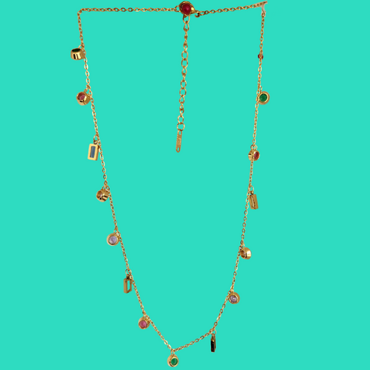 Gold necklace with small pendants on a teal background