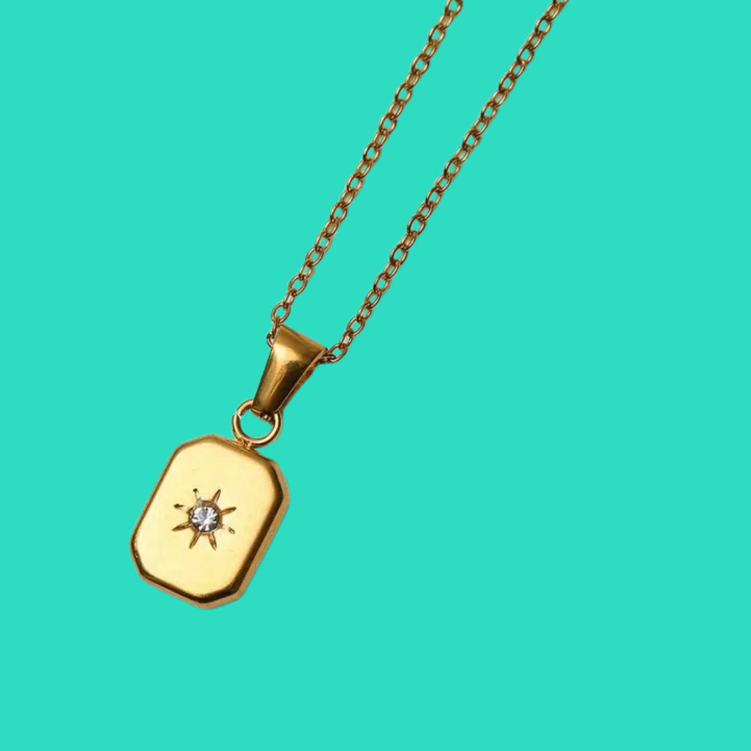 Gold necklace with a pendant on a turquoise background