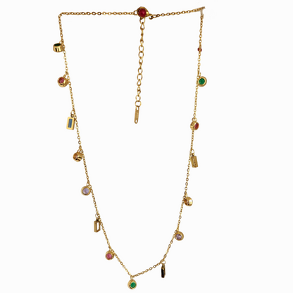 Gold necklace with colorful gemstones on a light green background