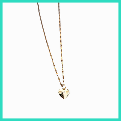 Gold heart-shaped pendant necklace on a light green background