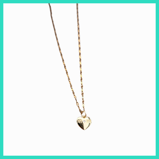 Gold heart-shaped pendant necklace on a light green background