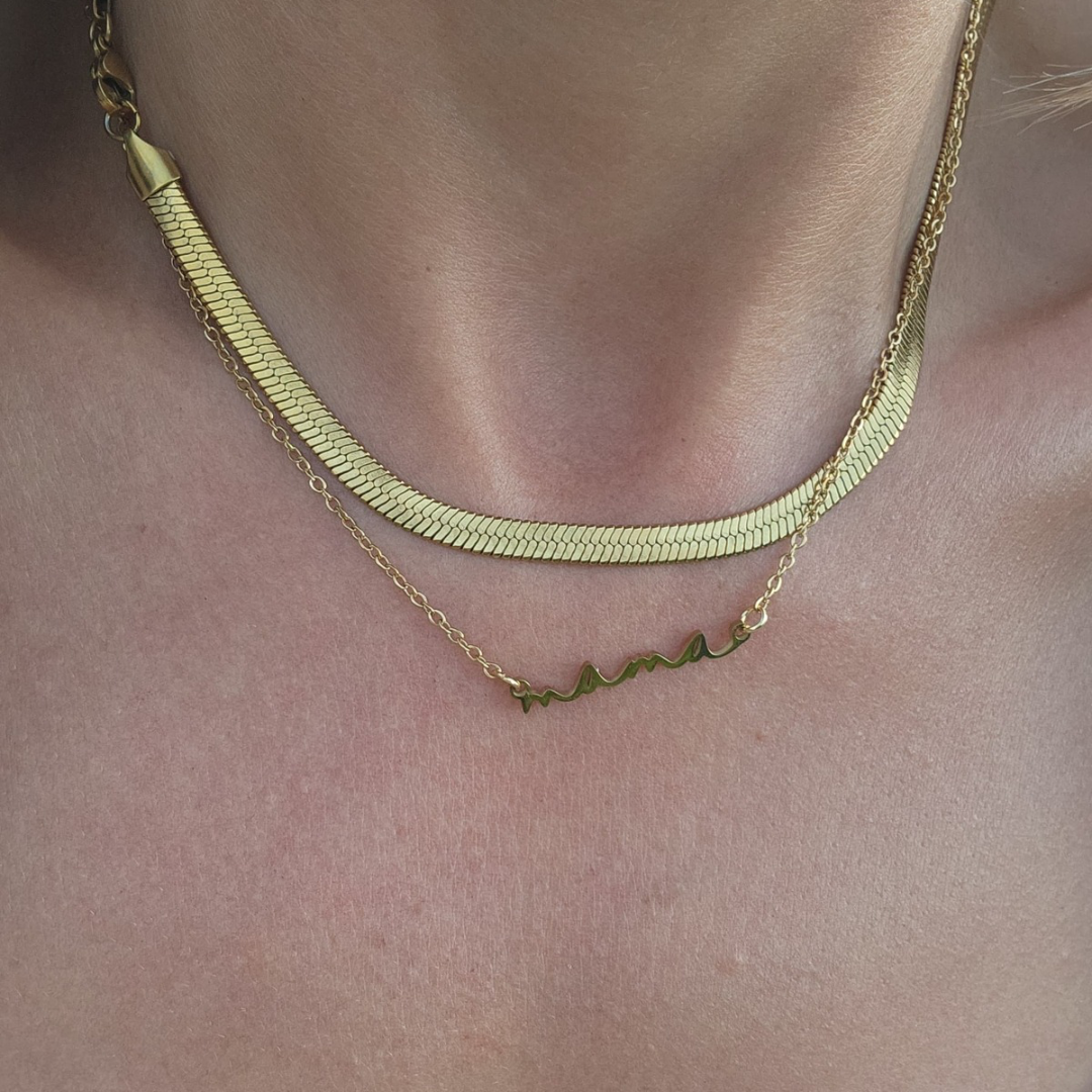 Two gold necklaces on a person's neck