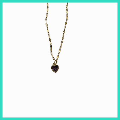 Gold necklace with a heart-shaped purple gemstone pendant on a white background