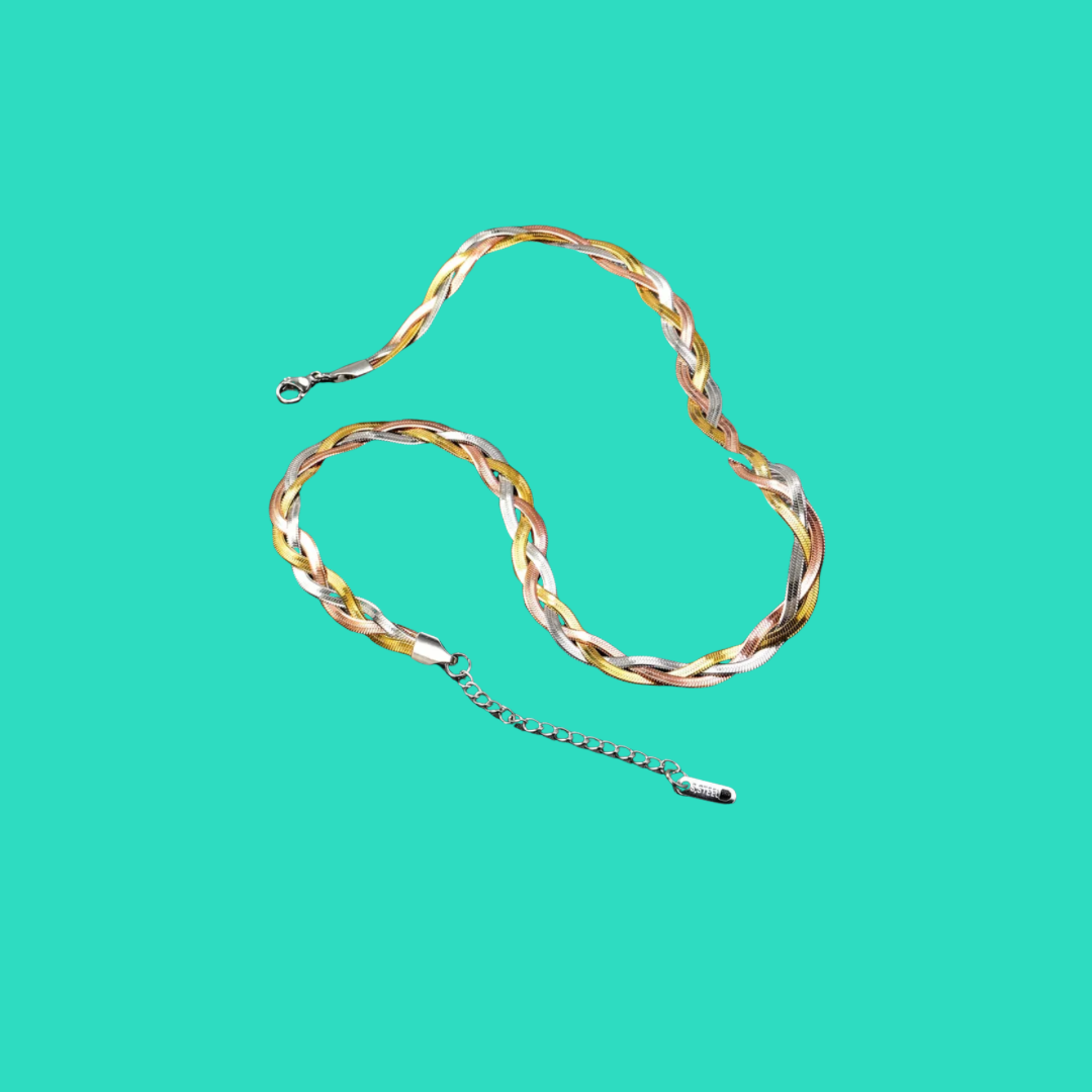 Gold and silver braided necklace on a teal background