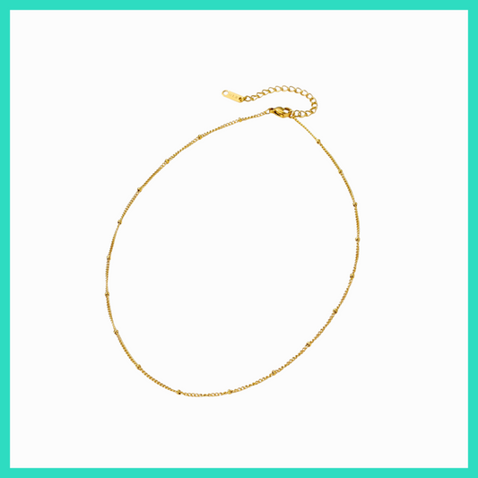 Gold necklace on a white background with a teal border
