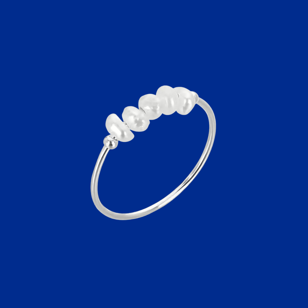 Silver ring with pearls on a blue background