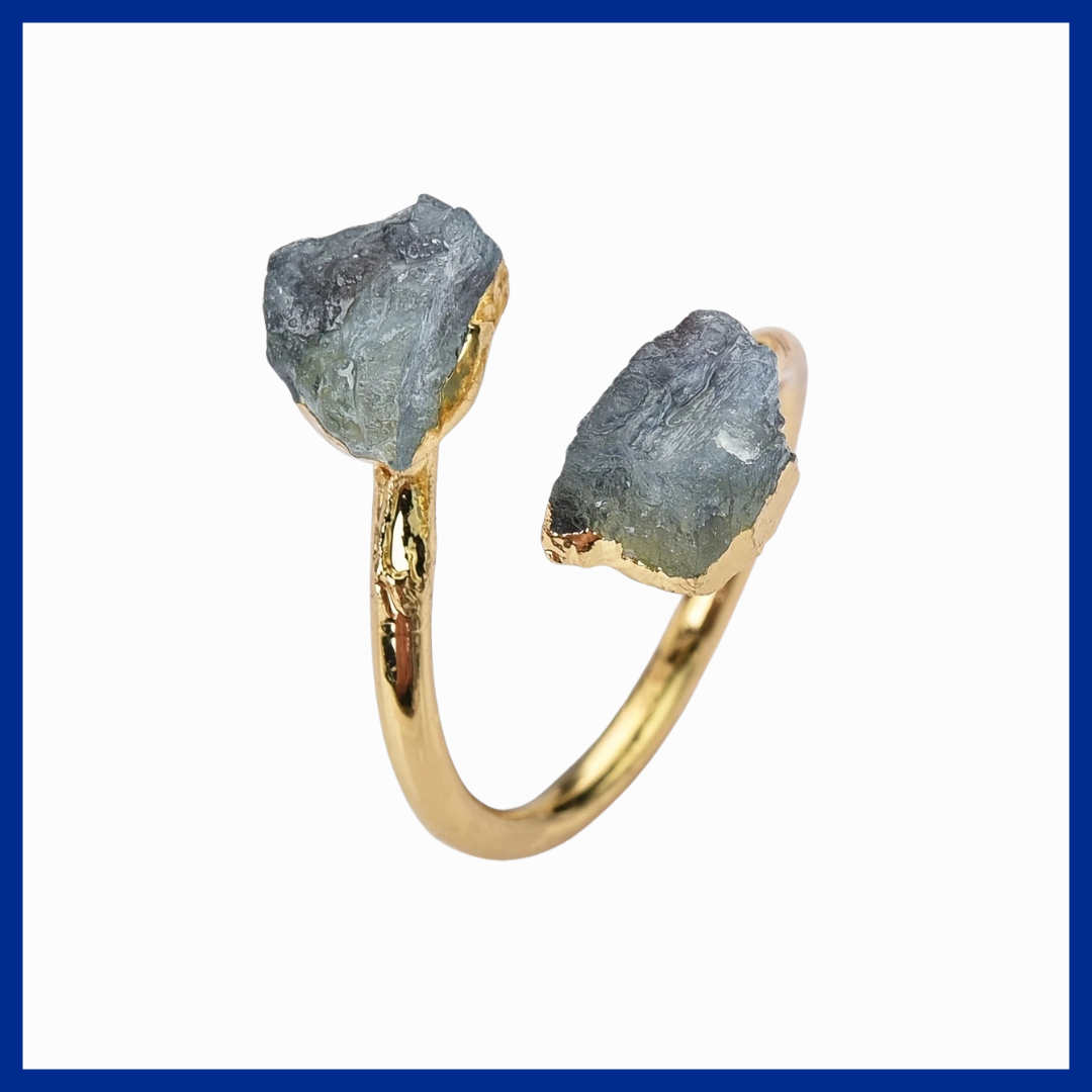 Gold ring with raw gemstones on a white background
