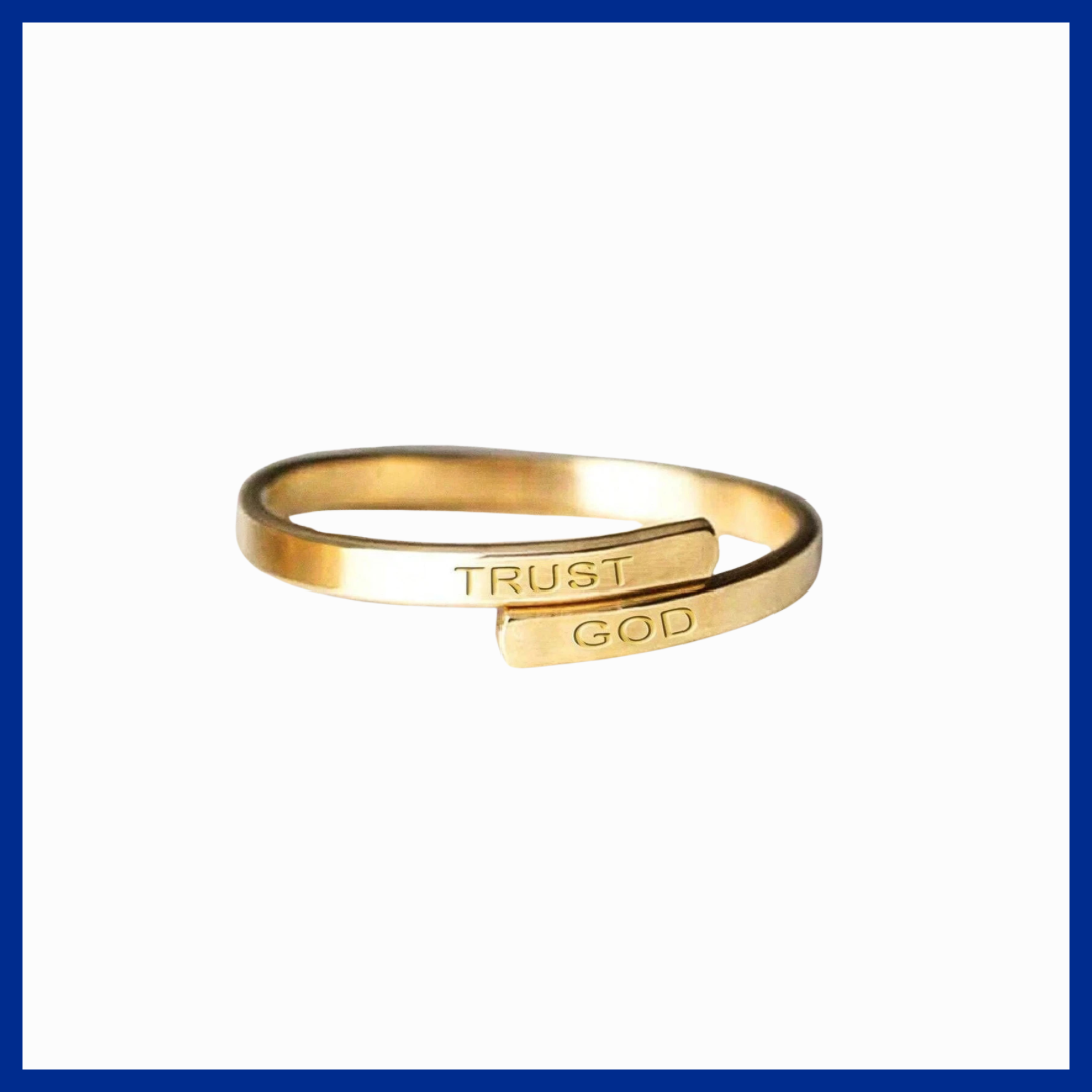Gold ring with 'TRUST GOD' engraving on a white background