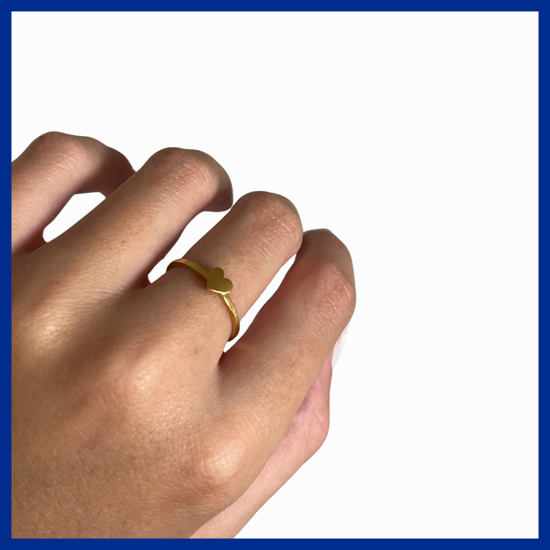 Hand wearing a gold ring on a white background