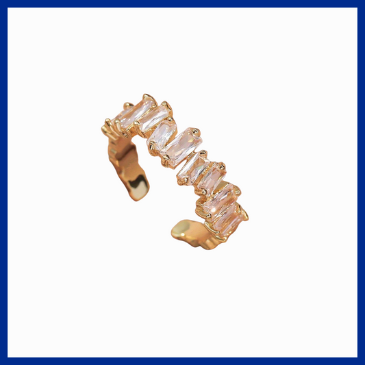 Gold earring with clear gemstones on a white background